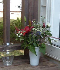 Old vase, new vase and flowers on customer's porch